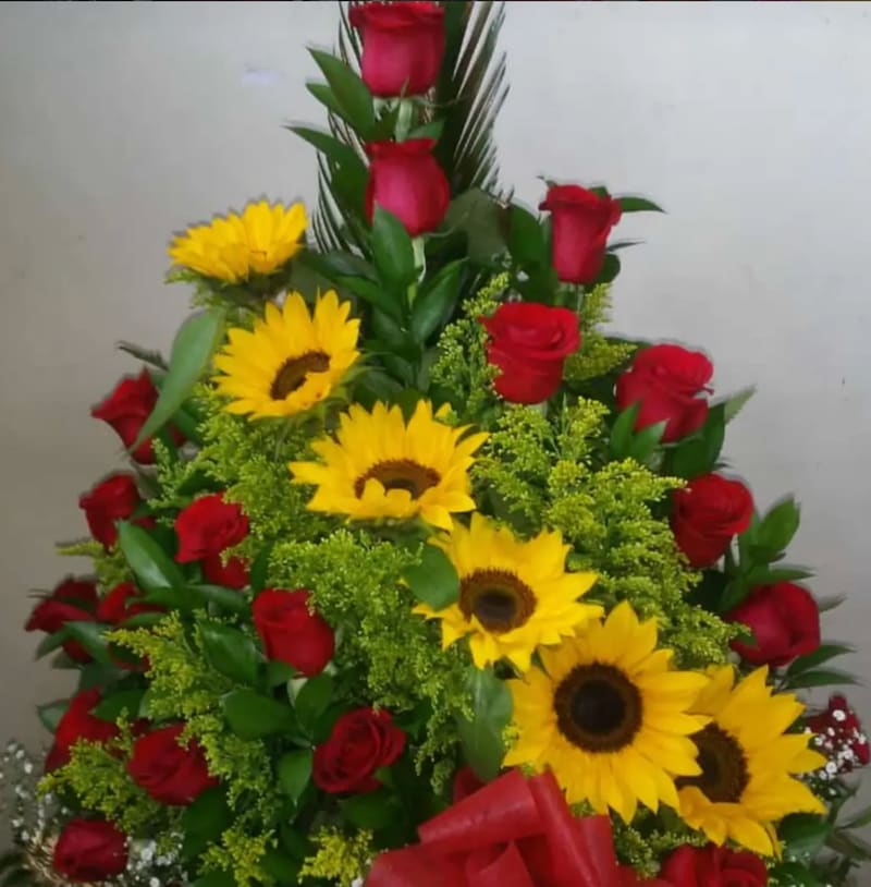 Arreglo floral alto con girasoles y rosas rojas